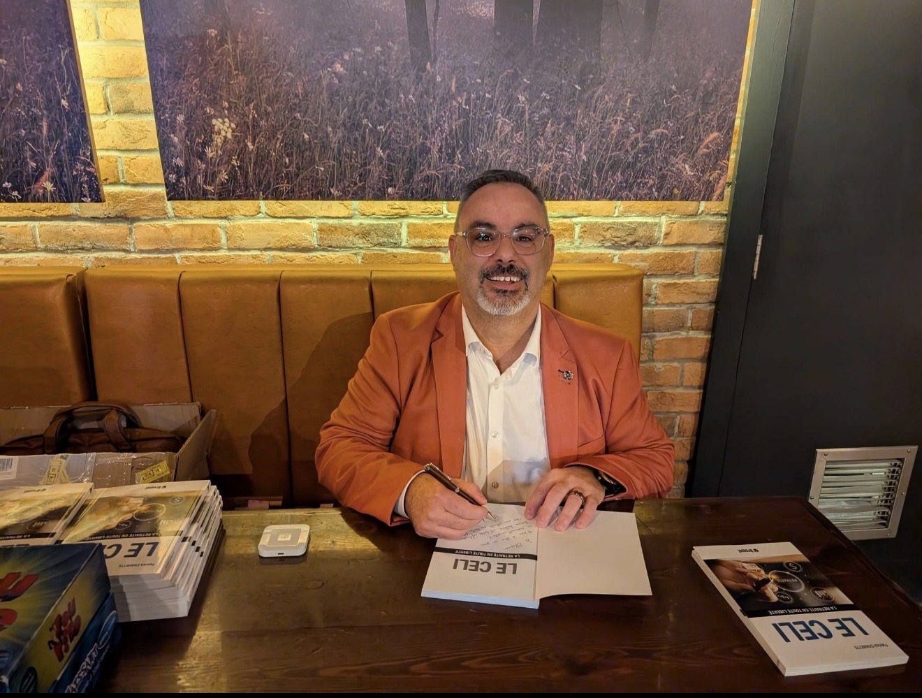 Patrick Charette signe un exemplaire du livre Le CELI : la retraite en toute liberté au Prana Café de Saint-Jérôme.